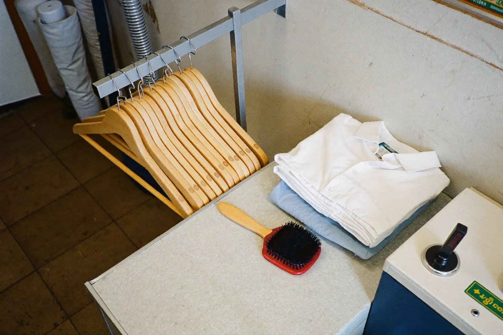 Iron, hangers and folded linen on the pressing worktop
