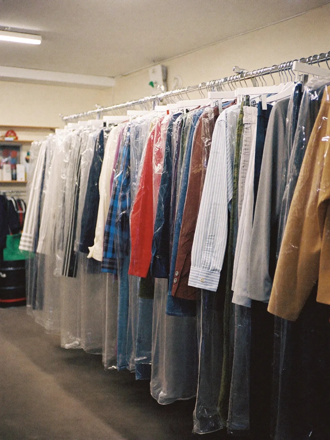 A rail of cleaned garments hanging in clear covers